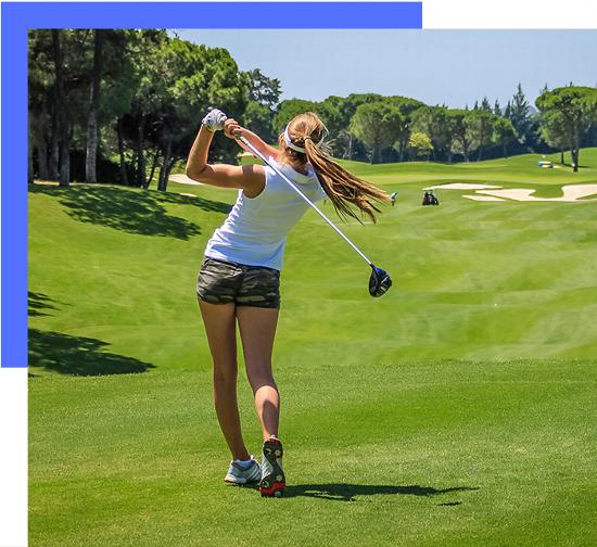 Female professional golfer swinging club on golf course